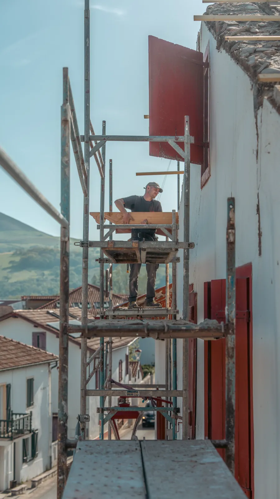 Échafaudage le long de la façade blanche d'une maison basque pendant la restauration