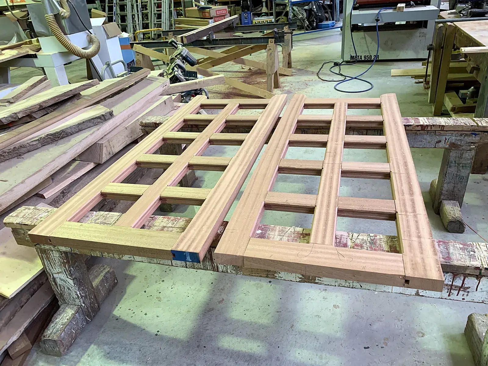 Deux châssis à petits bois en bois exotique en cours de fabrication sur l'établi de l'atelier