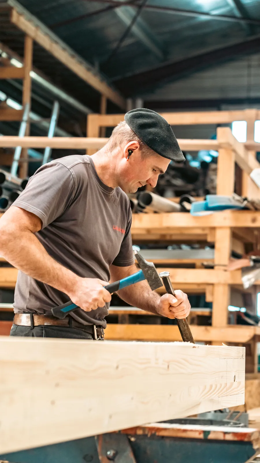 Menuisier ajustant une pièce de bois massif au ciseau à bois dans l'atelier